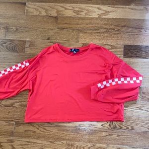 Red cropped long sleeve with checkers on sleeves.